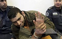 Palestinian Eyad Abu, shot through a glass partition, waves to his family in the court of Ashkelon, Israel, Sunday, Jan. 26, 2014. (photo credit: AP/Tsafrir Abayov)