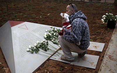A man reads the text from a new monument honoring gays and lesbians persecuted by the Nazis, in Tel Aviv on Friday (photo credit: AP/Oded Balilty)
