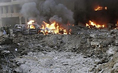 Vehicles burn following a bomb attack that targeted the motorcade of former Prime Minister Rafik Hariri, killing him and 22 others in Beirut, Lebanon, on Monday, February 14, 2005. (photo credit: AP Photo/File)