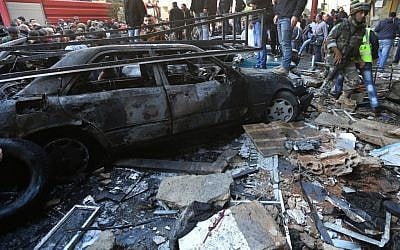 A Lebanese army soldier walks through the site of a car bombing in the southern suburb of Beirut, Lebanon, Tuesday, Jan. 21, 2014. (Photo credit: AP/Hussein Malla)