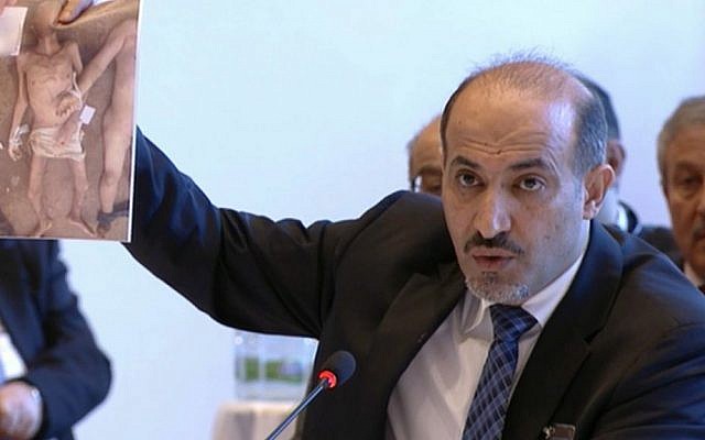 Amhad al-Jarba, the head of Syria's Western-backed Syrian National Coalition, holds up an image of alleged torture victims, during Syrian peace talks in Montreux, Switzerland, Jan. 22, 2014 (photo credit: AP) Amhad al-Jarba, the head of Syria's Western-backed Syrian National Coalition, holds up an image of alleged torture victims, during Syrian peace talks in Montreux, Switzerland, Jan. 22, 2014 (photo credit: AP)