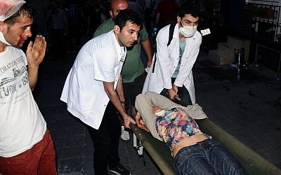 Volunteer Turkish doctors help a demonstrator overcome from pepper gas during clashes with riot police near Taksim Square in Istanbul, Turkey, May 31, 2013.  (photo credit: AP/Emrah Gurel)