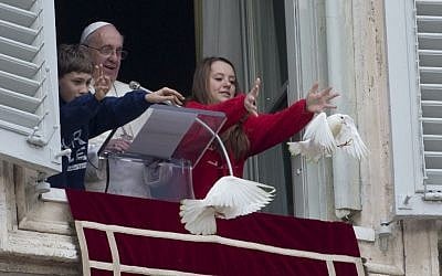Pope Francis looks on as two children free doves during the Angelus prayer he celebrated from the window of his studio overlooking St. Peter's Square, at the Vatican, Sunday, Jan. 26, 2014. (photo credit: AP/Gregorio Borgia)