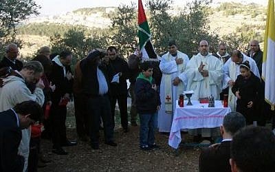 The Beit Jala Roman Catholic parish priest leads a mass to protest against Israel's decision to build a new section of the security fence through the Cremisan valley on January 24, 2014 (photo credit: Musa al-Shaer/AFP)