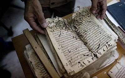 An employee shows an old manuscript at the al-Aqsa mosque compound library in Jerusalem. The library has a collection of some 4,000 old manuscripts with about a quarter considered in poor condition.  (photo credit: AP Photo/Dusan Vranic)