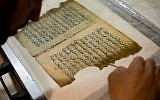 In this photo taken on Monday, Jan. 27, 2014, an employee works on a restoration of an old manuscript at the al-Aqsa mosque compound library in Jerusalem.  (photo credit: AP Photo/Dusan Vranic)
