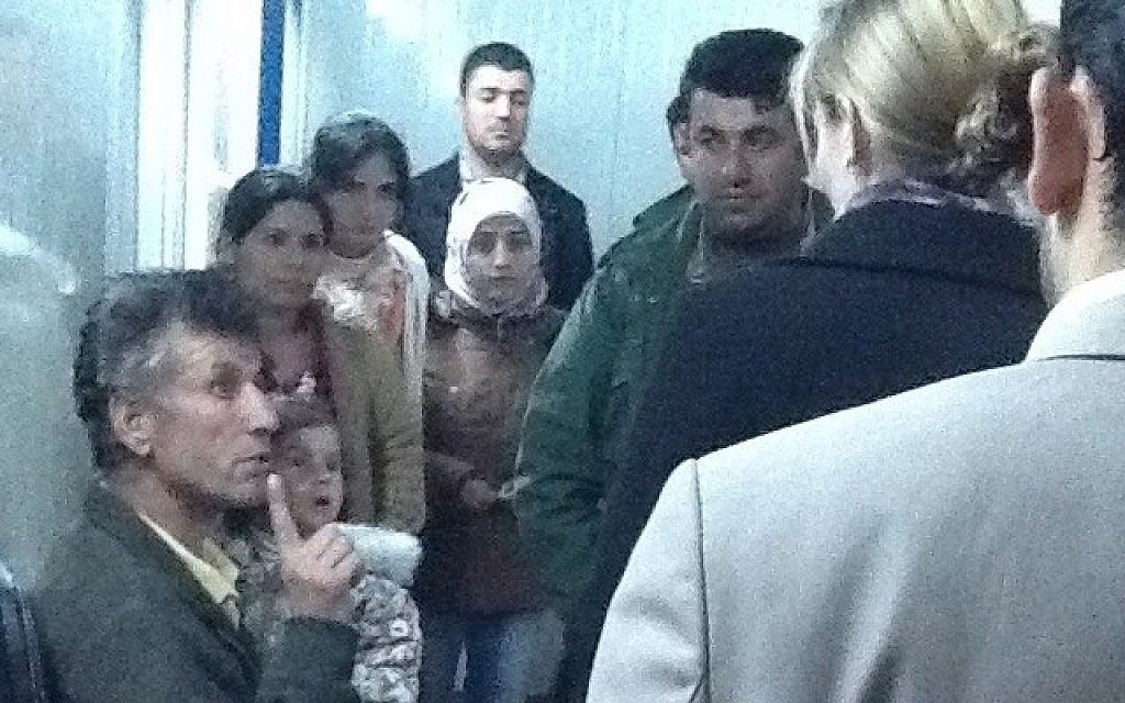 A Syrian Kurdish refugee family talk to Shevet Achim staff about their sick child (photo credit: Times of Israel/Lazar Berman)