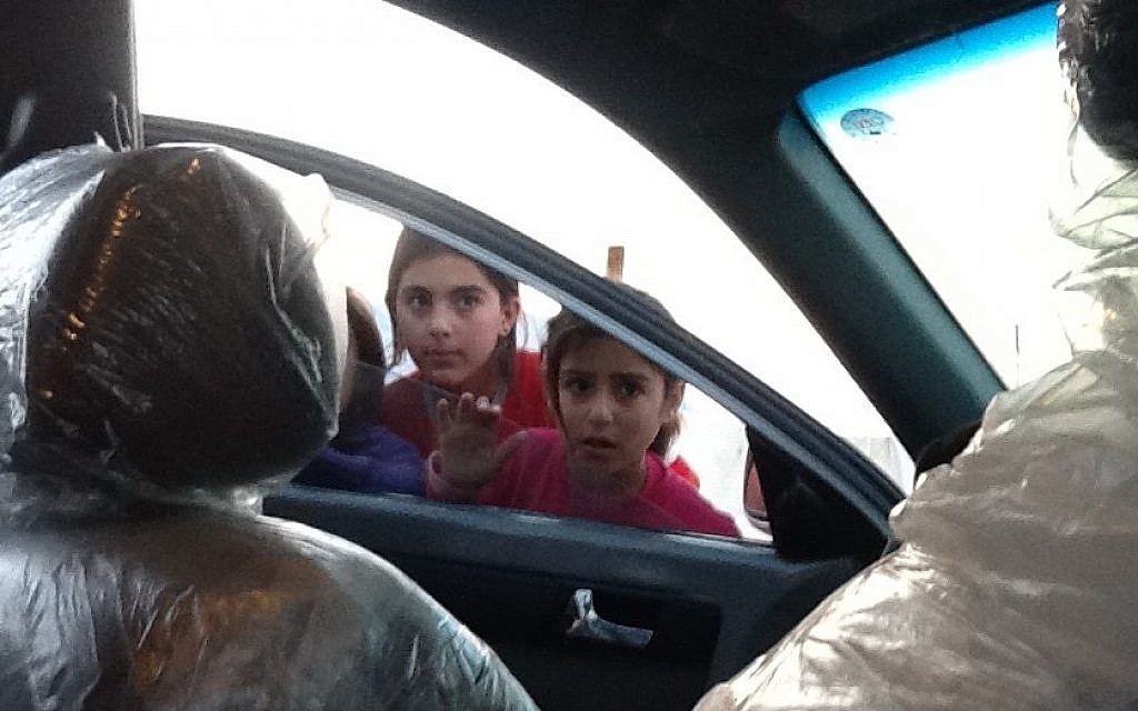 Children peer into Shevet Achim's car in a refugee camp for Syrian Kurds in Iraqi Kurdistan (photo credit: Times of Israel/Lazar Berman)
