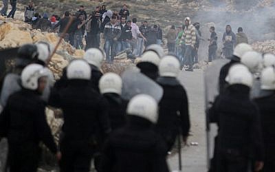 Protesters from the Palestinian refugee camp of al-Jalazoun, clash with Palestinian police as they block the main road leading to the West Bank city of Ramallah to demonstrate against the reduction of aid to refugees given by United Nation's UNRWA on January 12, 2014 (photo credit: Issam Rimawi/Flash90)