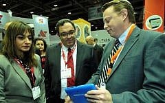 Education Minister Director Michal Cohen (L.) and Education Minister Shai Piron (C.) look on as Fourier CEO Ken Zwiebel demonstrates an Einstein tablet+ at the Bett Show in London last week (Photo credit: Courtesy)