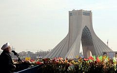 Iranian President Hassan Rouhani waves as he delivers a speech during a rally in Tehran's Azadi Square (Freedom Square) to mark the 35th anniversary of the Islamic Revolution on February 11, 2014. (photo credit: AFP/ATTA KENARE)