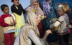 US actress and UNHCR Special Envoy Angelina Jolie talking to a young Syrian refugee on February 23, 2014 at a refugee camp near the Lebanese village of Zahle in the Bekaa valley (photo credit: AFP PHOTO /HO /UNHCR/A.MCCONEEL)