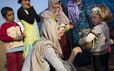 US actress and UNHCR Special Envoy Angelina Jolie talking to a young Syrian refugee on February 23, 2014 at a refugee camp near the Lebanese village of Zahle in the Bekaa valley (photo credit: AFP PHOTO /HO /UNHCR/A.MCCONEEL)