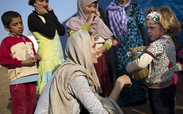 US actress and UNHCR Special Envoy Angelina Jolie talking to a young Syrian refugee on February 23, 2014 at a refugee camp near the Lebanese village of Zahle in the Bekaa valley (photo credit: AFP PHOTO /HO /UNHCR/A.MCCONEEL) US actress and UNHCR Special Envoy Angelina Jolie talking to a young Syrian refugee on February 23, 2014 at a refugee camp near the Lebanese village of Zahle in the Bekaa valley (photo credit: AFP PHOTO /HO /UNHCR/A.MCCONEEL)