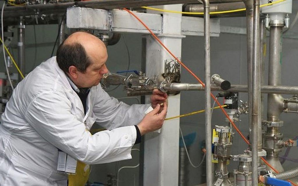 An International Atomic Energy Agency inspector disconnects the connections between the twin cascades for 20% uranium production at Natanz nuclear power plant south of Tehran on January, 20, 2014 (Kazem Ghane/IRNA/AFP)