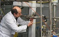 An International Atomic Energy Agency inspector disconnects the connections between the twin cascades for 20% uranium production at Natanz nuclear power plant south of Tehran on January, 20, 2014 (Kazem Ghane/IRNA/AFP)