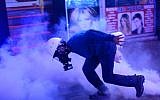 A protester throws a gas canister back at anti-riot police during a protest against the Turkish government's newly proposed restrictions on the use of Internet, on Istiklal avenue in Istanbul, on Saturday, February 8, 2014 (photo credit: AFP Bulent Kilic)