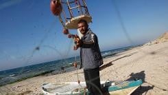 Palestinian fisherman Jawdat Ghrab, who said he scooped 2,500-year old bronze statue of the Greek God Apollo from the seabed last August, seen on the beach of the Deir Al-Balah district, in the central Gaza Strip, on February 12, 2014. (photo credit: AFP/File Said Khatib)