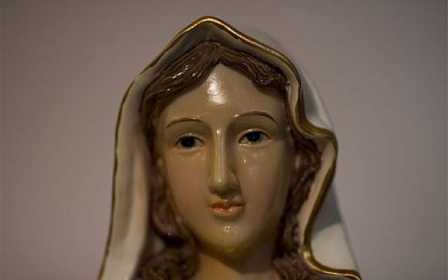 A statue of the Virgin Mary that residents say 'weeps' oil has attracted thousands of visitors in the last week to an apartment belonging to the Khoury family, in Tarshiha, a small town near the Lebanon border, Tuesday, February 11, 2014 (photo credit: (AP Photo/Ariel Schalit) A statue of the Virgin Mary that residents say 'weeps' oil has attracted thousands of visitors in the last week to an apartment belonging to the Khoury family, in Tarshiha, a small town near the Lebanon border, Tuesday, February 11, 2014 (photo credit: (AP Photo/Ariel Schalit)