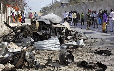 Somalis gather near the wreckage of one of the vehicles used for a car bomb, following a terrorist attack on the presidential palace in Mogadishu, Somalia Friday, Feb. 21, 2014. (photo credit: AP/Farah Abdi Warsameh)