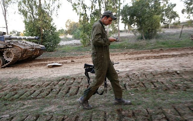 A member of a tank crew checking his phone during Operation Cast Lead, December 2008. (photo credit: Miriam Alster/Flash90)