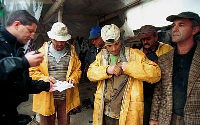 Migration police checks the identifications of immigrant construction workers in Petah Tikva. (Photo credit: Moshe Shai/Flash90)
