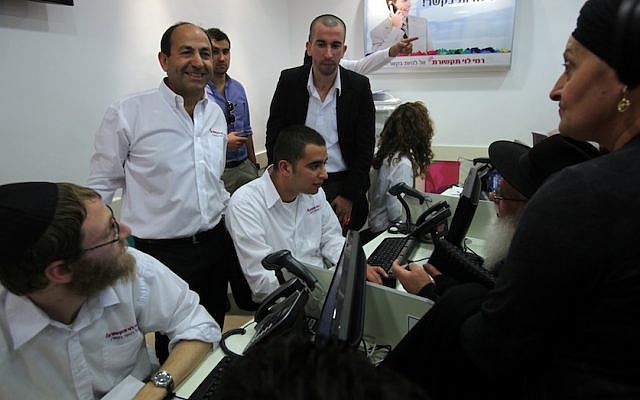 Rami Levy (standing, left) at a cellphone sales center in one of the supermarkets bearing his name. (photo credit: Yossi Zamir/Flash90)