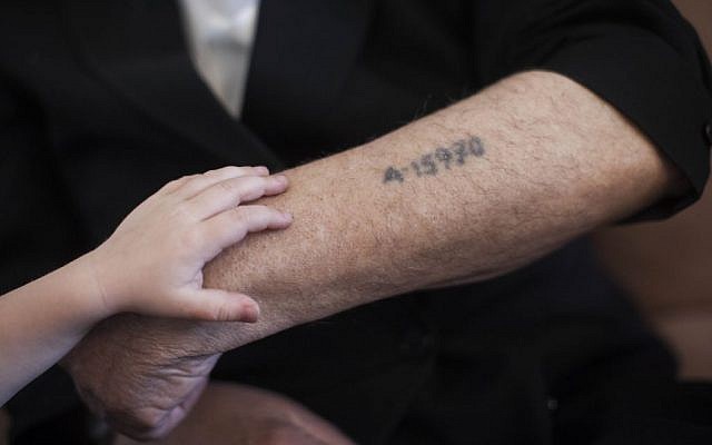 A little boy puts a hand on his grandfather's arm near his concentration camp prisoner number tattoo, in Jerusalem on May 24, 2013. (photo credit: Yonatan Sindel/Flash90) A little boy puts a hand on his grandfather's arm near his concentration camp prisoner number tattoo, in Jerusalem on May 24, 2013. (photo credit: Yonatan Sindel/Flash90)