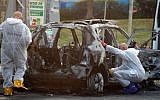 Members of the police bomb squad investigate a car that exploded in the city of Petah Tikvah, February 3, 2014. (Photo credit: Gideon Markowicz/Flash90)