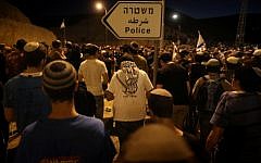 Israelis settlers and right-wing activists hold evening prayers after attending a march in the area known as E1 near the Israeli settlement of Ma'ale Adumim, on February 13, 2014. (photo credit: Yonatan Sindel/Flash90)