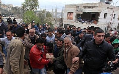 Palestinian residents evacuate the body of Mu'taz Washha from his house toward an ambulance after he was killed during a reported Israeli army operation, in the West Bank town of Bir Zeit, Thursday, Feb. 27, 2014 (photo credit: Issam Rimawi/Flash90)