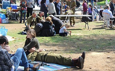 Following a 50-kilometer, all-night march, paratroopers relax with their families Feb 18. before the ceremony that awarded them their red berets. (The Times of Israel/Rebecca McKinsey) Following a grueling 50-kilometer, all-night march, paratroopers relax with their families Feb 18. before the ceremony that awarded them their red berets. (The Times of Israel/Rebecca McKinsey)