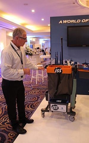 Rafi Zemach, CEO of the ISS southern cleaning division, discusses the trolleys that cleaning employees use to carry environmentally friendly supplies during an ISS exhibition in Tel Aviv Feb. 2. (Photo credit: Times of Israel/Rebecca McKinsey) Rafi Zemach, CEO of the ISS southern cleaning division, discusses the trolleys that cleaning employees use to carry environmentally friendly supplies during an ISS exhibition in Tel Aviv Feb. 2. (Photo credit: Times of Israel/Rebecca McKinsey)