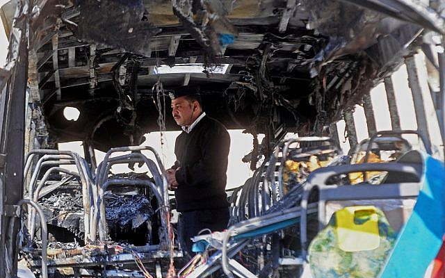 An Egyptian policeman inspects a damaged bus after a deadly explosion Sunday near the Egyptian border crossing with Israel in Taba, Egypt, Monday, Feb. 17, 2014. (photo credit: AP/Nameer Galal) An Egyptian policeman inspects a damaged bus after a deadly explosion Sunday near the Egyptian border crossing with Israel in Taba, Egypt, Monday, Feb. 17, 2014. (photo credit: AP/Nameer Galal)