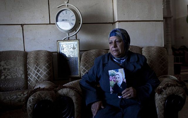 Palestinian Khadra al-Akhras poses with a photo of her late daughter Ayat al-Akhras, who blew herself up in a suicide bombing outside a Jerusalem supermarket in 2002, at the family house in the West Bank city of Bethlehem. February 1, 2014 (AP Photo/Nasser Nasser) Palestinian Khadra al-Akhras poses with a photo of her late daughter Ayat al-Akhras, who blew herself up in a suicide bombing outside a Jerusalem supermarket in 2002, at the family house in the West Bank city of Bethlehem. February 1, 2014 (AP Photo/Nasser Nasser)