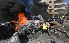 Lebanese firefighters extinguish burned cars at the site of an explosion, near the Kuwaiti Embassy and Iran's cultural center, in the suburb of Beir Hassan, Beirut, Lebanon, Wednesday, February 19, 2014 (photo credit: AP/Hussein Malla)