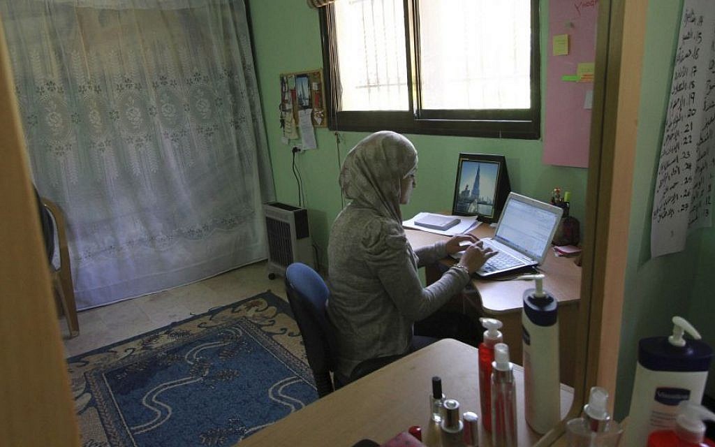 Abeer Abu Ghaith, who set up an internet employment brokerage and software development firm, is reflected in a mirror in her home while she works on her laptop in the West Bank village of Dura, Tuesday, Feb. 11, 2014. (photo credit: AP/Nasser Shiyoukhi) Abeer Abu Ghaith, who set up an internet employment brokerage and software development firm, is reflected in a mirror in her home while she works on her laptop in the West Bank village of Dura, Tuesday, Feb. 11, 2014. (photo credit: AP/Nasser Shiyoukhi)