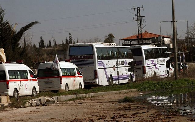 Syrian people on two buses followed by the Syrian Arab Red Crescent's vehicles evacuate the battleground city of Homs, Friday, February 7, 2014 (photo credit: AP) Syrian people on two buses followed by the Syrian Arab Red Crescent's vehicles evacuate the battleground city of Homs, Friday, February 7, 2014 (photo credit: AP)