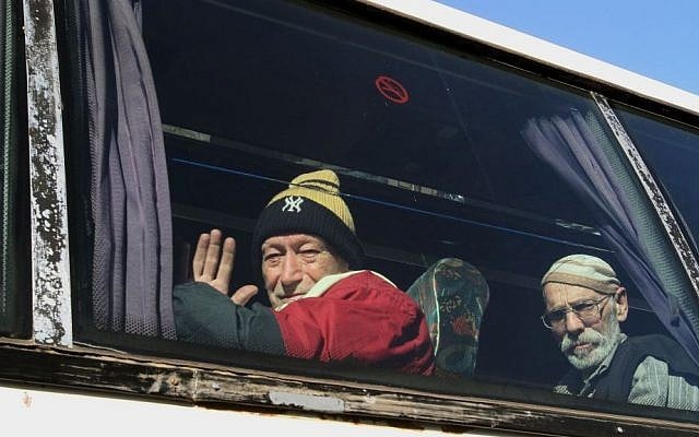 Elderly men sitting on a bus pose for a photograph as they evacuate the battleground city of Homs, Syria, on Friday, Feb. 7, 2014 (photo credit: AP) Elderly men sitting on a bus pose for a photograph as they evacuate the battleground city of Homs, Syria, on Friday, Feb. 7, 2014 (photo credit: AP)