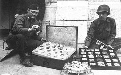 This photo provided by The Monuments Men Foundation for the Preservation of Art of Dallas, shows Monuments Man James Rorimer, left, and Sgt. Antonio Valim examining valuable art objects at Neuschwanstein Castle in Germany which were stolen from the Rothschild collection in France by the ERR and found in the castle in May of 1945. (AP Photo/National Archives and Records Administration)