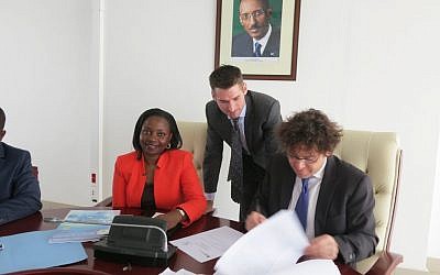 Chaim Motzen, managing director of Gigawatt Global (right), signs a power purchase agreement for a solar field in Rwanda at a ceremony in Kigali, Rwanda, as Eng. Emma Francoise Isumbingabo, Rwanda minister of state in charge of energy and water and local project manager Trevor Green of Remote Partners look on. (Photo credit: Courtesy)