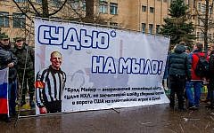 In this handout photo provided by Young Guards of United Russia party press service shows a group of demonstrators holding a banner with a photo of American Ice Hockey referee Brad Meier and message reading 'Turn the referee into soap.' (AP Photo/Voroshirin Dmitriy, Young Guards)
