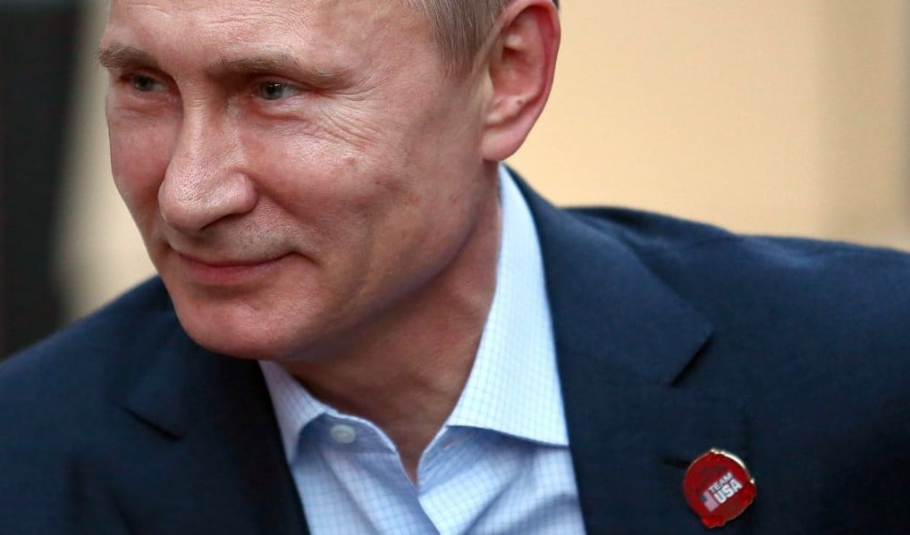 Russian President Vladimir Putin wears a Team USA pin while visiting USA House in the Olympic Village during the 2014 Winter Olympics on Friday, Feb. 14, 2014, in Sochi, Russia. (photo credit: AP Photo/Marianna Massey, USOC Pool)