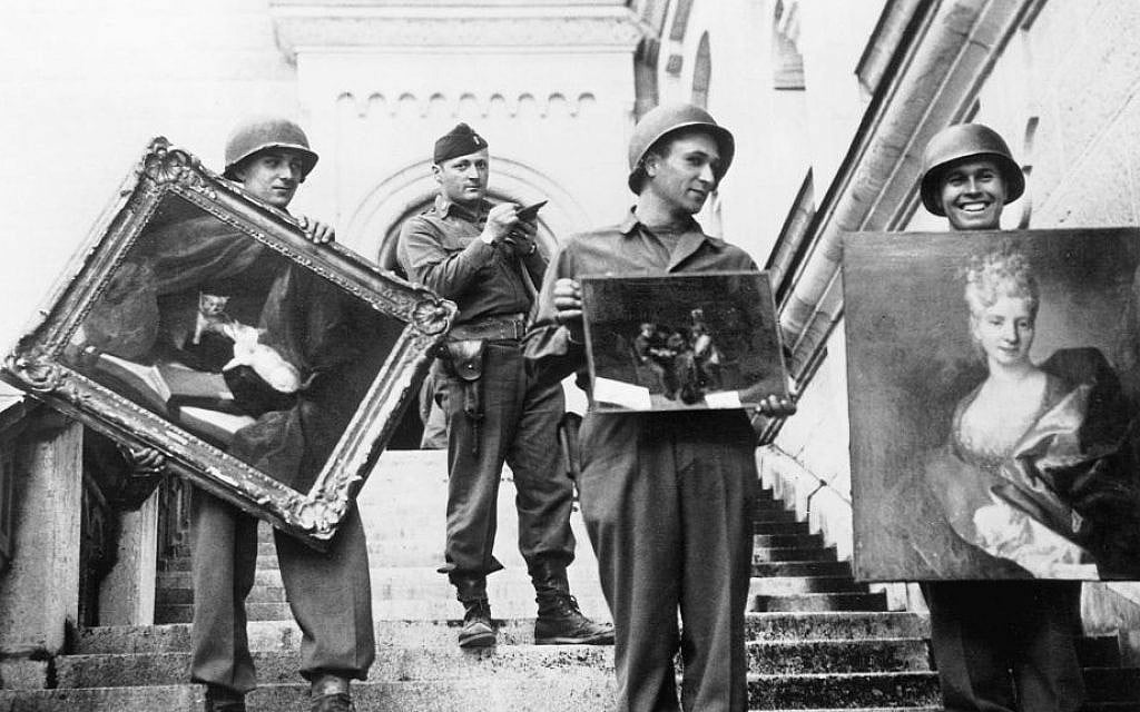 This photo provided by The Monuments Men Foundation for the Preservation of Art of Dallas, shows Monuments Man James Rorimer, with notepad, as he supervises American GI's hand-carrying paintings down the steps of the castle in Neuschwanstein, Germany in May of 1945. (photo credit: AP/National Archives and Records Administration) This photo provided by The Monuments Men Foundation for the Preservation of Art of Dallas, shows Monuments Man James Rorimer, with notepad, as he supervises American GI's hand-carrying paintings down the steps of the castle in Neuschwanstein, Germany in May of 1945. (photo credit: AP/National Archives and Records Administration)
