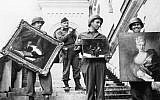 This photo provided by The Monuments Men Foundation for the Preservation of Art of Dallas, shows Monuments Man James Rorimer, with notepad, as he supervises American GI's hand-carrying paintings down the steps of the castle in Neuschwanstein, Germany in May of 1945. (photo credit: AP/National Archives and Records Administration)