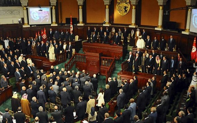 Tunisian parliament members and world leaders stand during a ceremony for the formal adoption of a new constitution, in Tunis, Friday, Feb. 7, 2014 Tunisian parliament members and world leaders stand during a ceremony for the formal adoption of a new constitution, in Tunis, Friday, Feb. 7, 2014