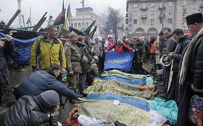 Activists and priests pay respects to protesters who were killed in clashes with police in Kiev, Ukraine, Thursday, February 20, 2014 (photo credit: AP/Efrem Lukatsky)