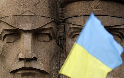 A Ukrainian flag flies in front of the KGB officers monuments in Kiev, Ukraine, Sunday, Feb. 23, 2014.  (photo credit: AP Photo/Darko Vojinovic)