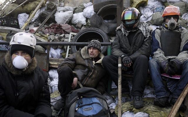 Anti-government protesters take a break on a barricade at Independence Square in Kiev, Ukraine, Friday, Feb. 21, 2014 (photo credit: AP/ Marko Drobnjakovic) Anti-government protesters take a break on a barricade at Independence Square in Kiev, Ukraine, Friday, Feb. 21, 2014 (photo credit: AP/ Marko Drobnjakovic)
