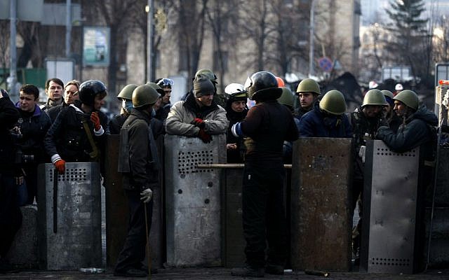 Anti-government protesters man a barricade on the outskirts of Independence Square in Kiev, Ukraine on Friday. (photo credit: AP Photo/ Marko Drobnjakovic) Anti-government protesters man a barricade on the outskirts of Independence Square in Kiev, Ukraine on Friday. (photo credit: AP Photo/ Marko Drobnjakovic)
